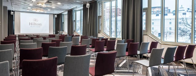 Theater-style meeting room with colorful chairs for corporate presentations and conferences.