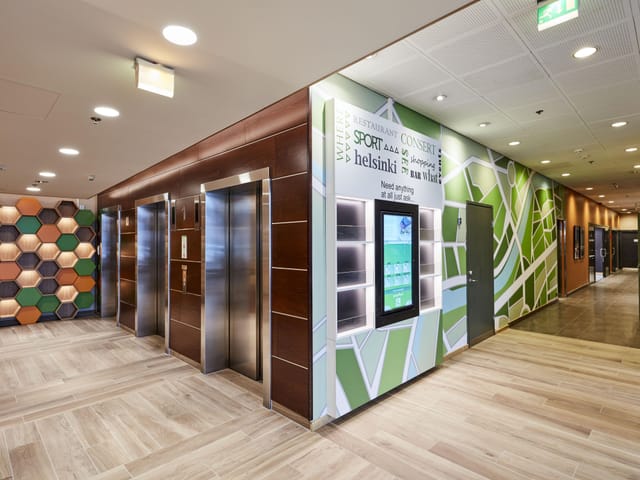 Modern conference lobby at Holiday Inn Helsinki with digital wayfinding for corporate events.