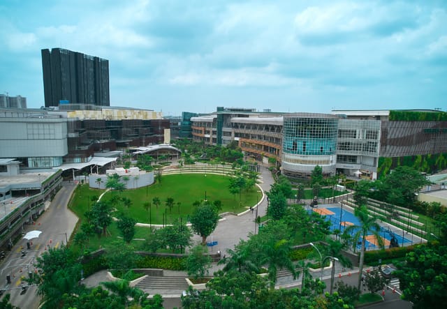 Modern Jaya Real Property condo venue with central green space for corporate networking events.