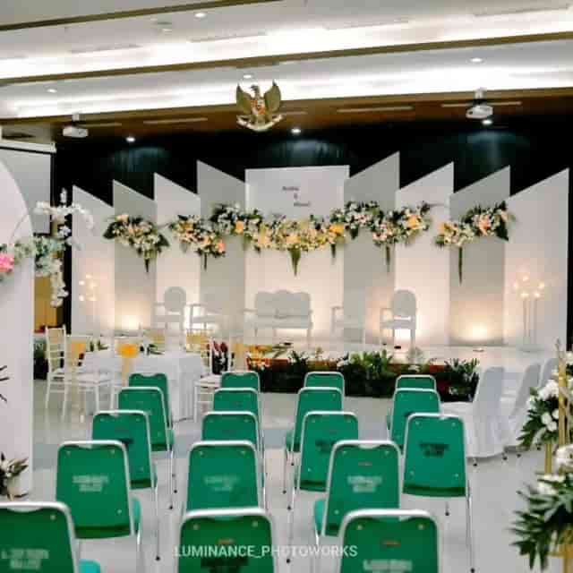 Modern wedding stage at The VIDA Ballroom featuring geometric floral backdrop and bridal furniture.
