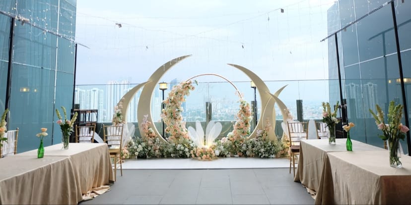 Rooftop event setup with moon-themed floral backdrop for corporate and social gatherings.