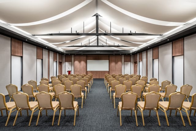 Modern conference room with architectural ceiling for corporate presentations and seminars.