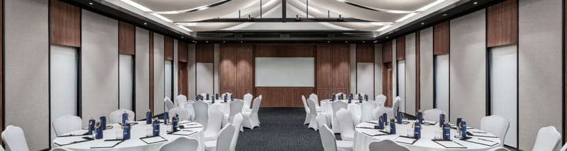 Upscale corporate banquet room with wood paneling for executive retreats and business events.