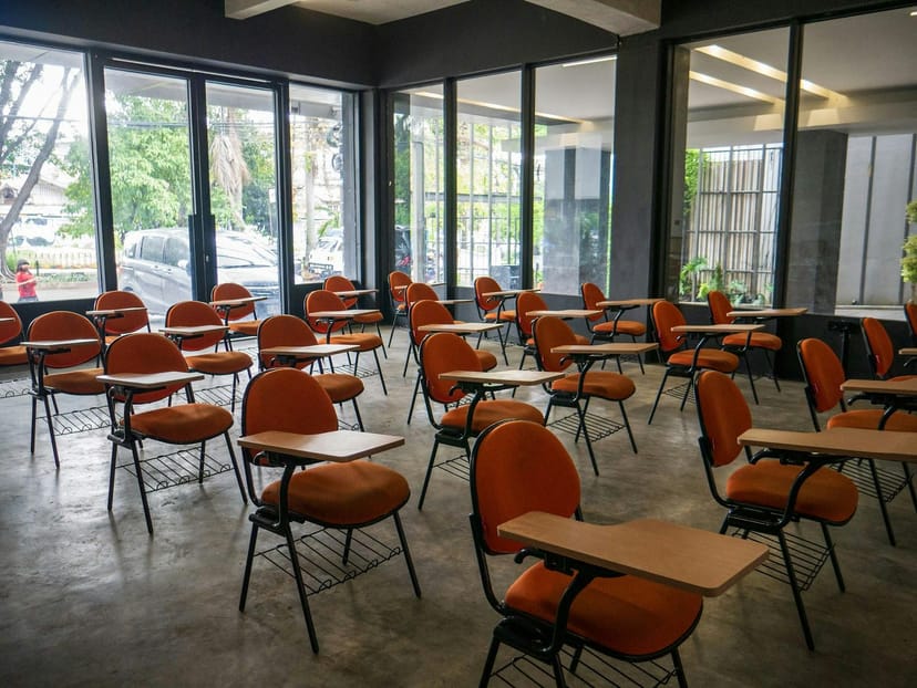 Orange tablet-arm chairs in Mantra Space private office for professional training workshops.