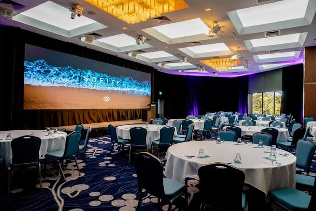 Luxury hotel ballroom with LED screen for corporate events and gala conferences.