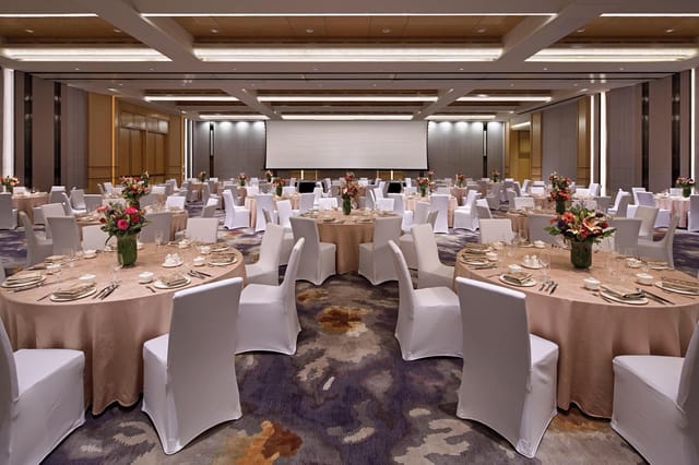Ballroom banquet setup with circular tables for corporate conferences or gala dinners.