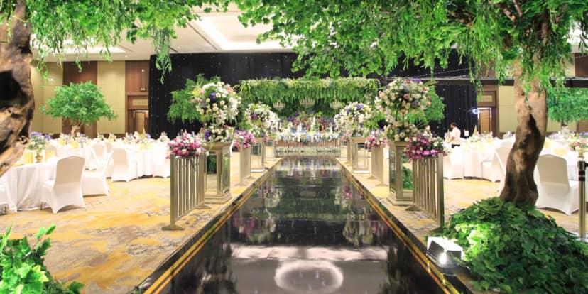 Black runway ballroom with enchanted forest canopy for luxury wedding gala event.