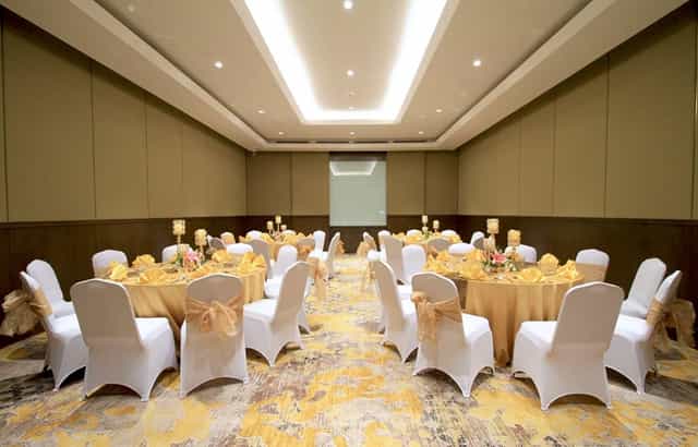 Ballroom at The Sultan Hotel Jakarta featuring round tables for intimate wedding or gala events.