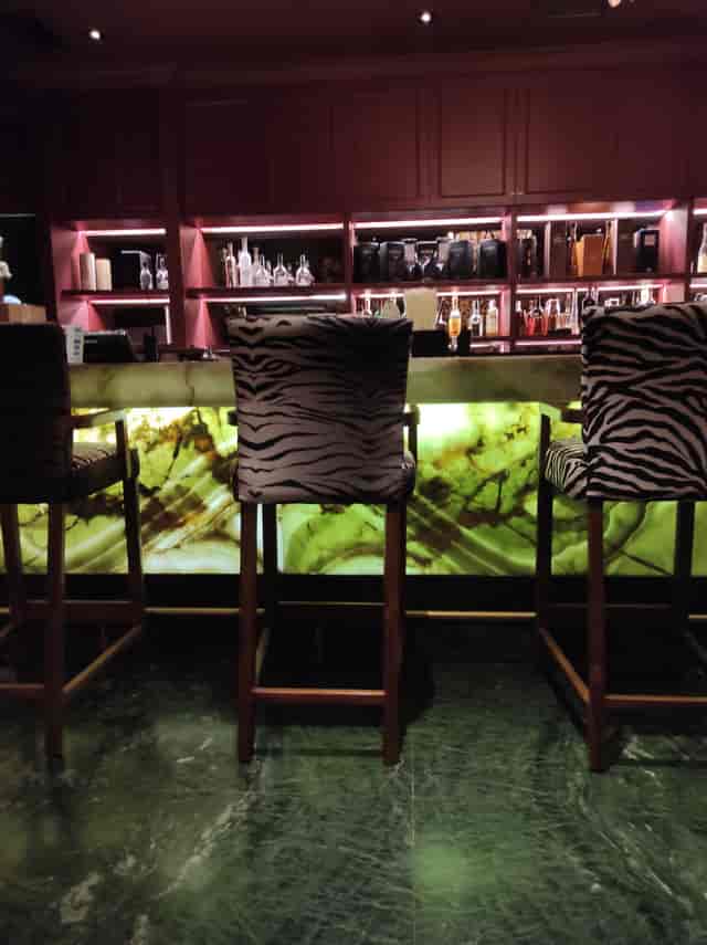 Ambrosia Private Club: Backlit onyx bar, luxury networking event venue, corporate reception space.