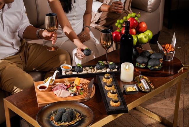 VIP hospitality lounge with charcoal appetizers and wine for corporate networking events.