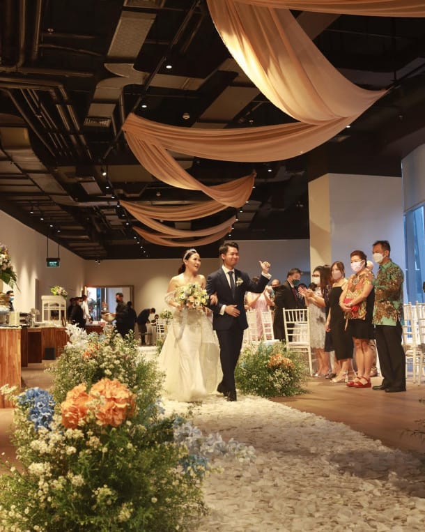 Alila SCBD wedding venue with elegant ceiling draping and floral aisle decor for luxury events.