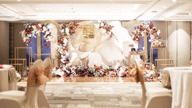 Wedding stage design at AYANA Midplaza Jakarta with tiered golden arches and luxury floral decor.