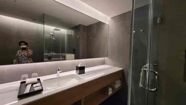 Modern hotel bathroom in Aloft South Jakarta, featuring walk-in shower for event room blocks.