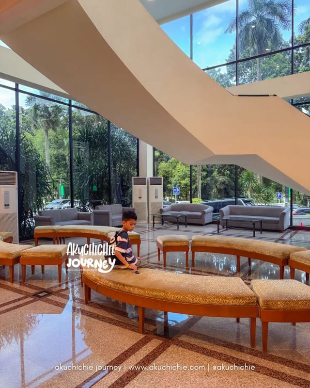 Modern Artotel Gelora Senayan breakout space with floor-to-ceiling windows for event registration.