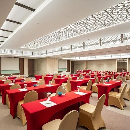 Conference room at Aston Kemayoran with red tables for corporate workshops and training seminars.