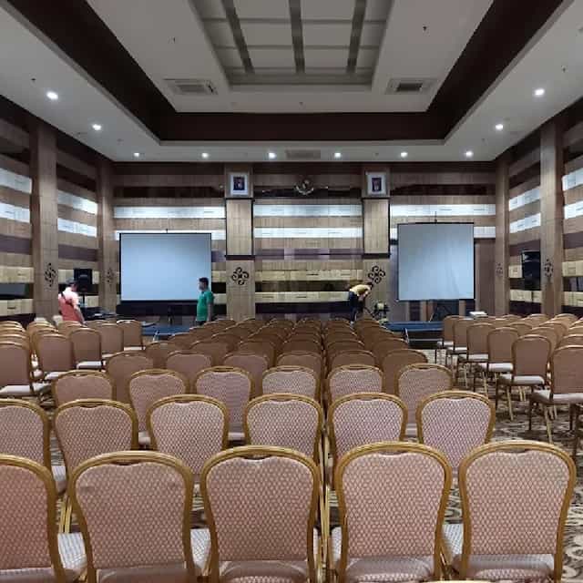 Grand Tjokro Jakarta ballroom theater setup with dual projection screens for corporate events.