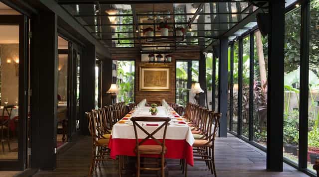 Private dining room in Patio Jakarta: upscale glass-walled boardroom for corporate event venue.