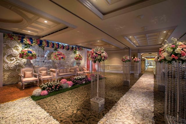 Elegant ballroom wedding venue with floral decor and crystal pillars, ideal for formal receptions.