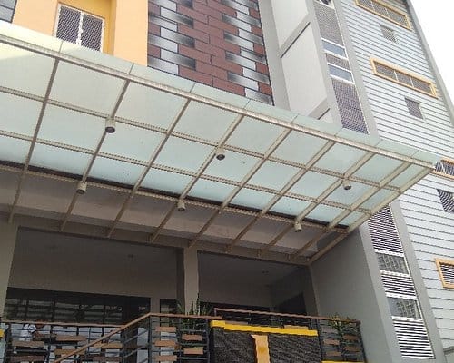 Modern Harlys Cafe entrance with glass porte-cochere for event venue and hotel arrivals.