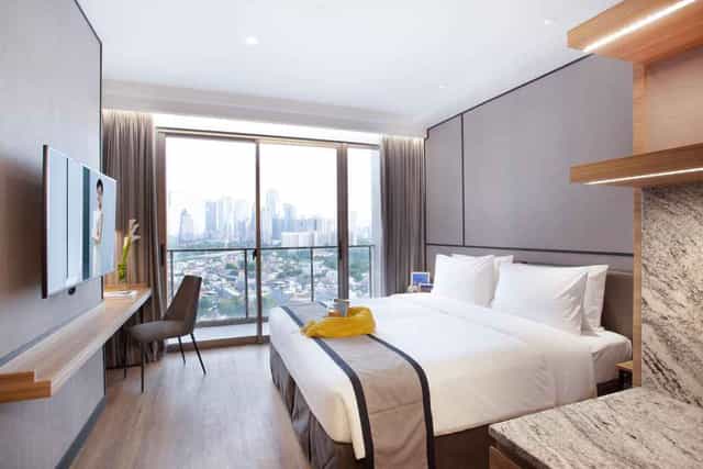 Modern guest room at Somerset Sudirman Jakarta with workspace for corporate incentive travel.