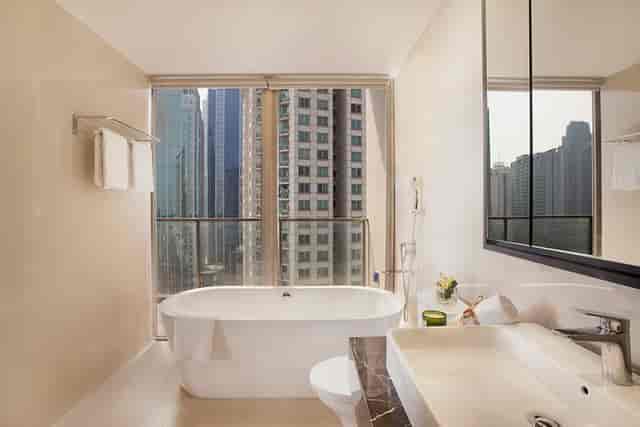 Upscale hotel bathroom with soaking tub and Jakarta city view for executive business events.
