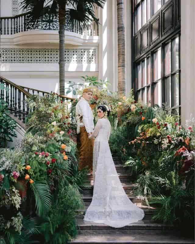 Wedding portrait at The Atrium, Sampoerna Strategic Square featuring lush botanical decor.