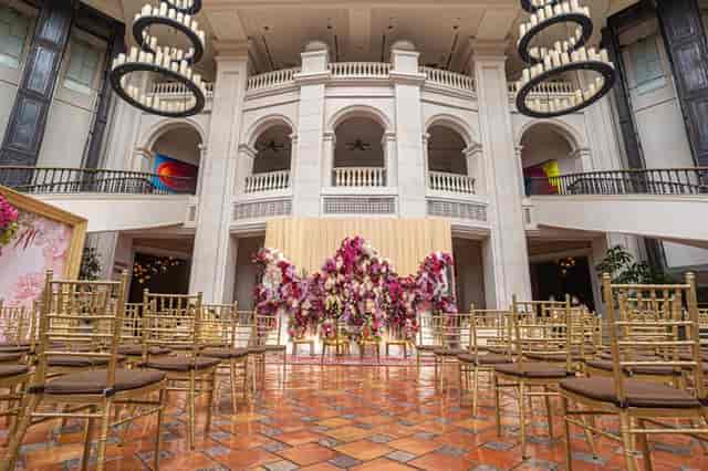 Elegant ballroom wedding venue with tiered chandeliers and gold chairs for luxury events.