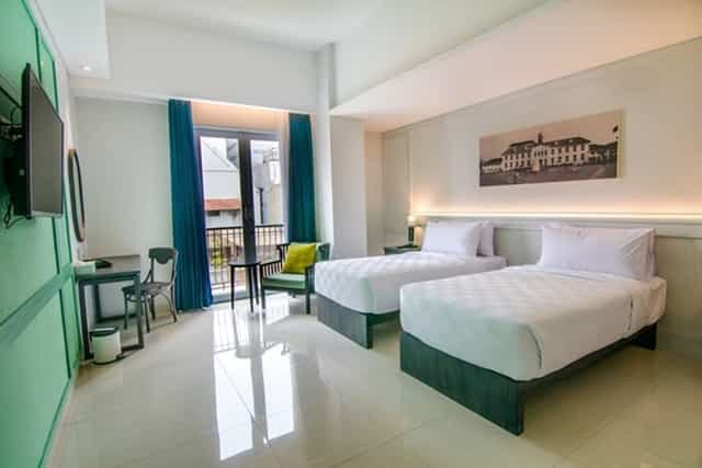 Twin-share hotel room with balcony for business conference and corporate stay.
