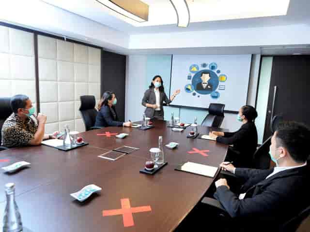 Socially distanced Kweni Boardroom setup with masked attendees for safe corporate meetings.