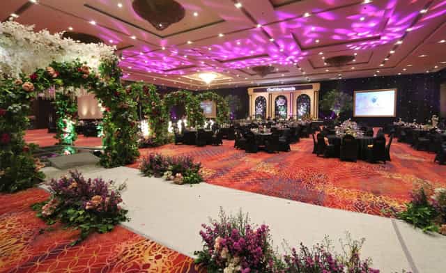 Hotel Bidakara ballroom with purple lighting and floral arch for gala and wedding event venue.