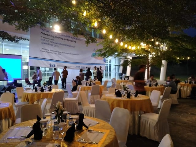 Felfest UI evening networking reception on outdoor patio with string lighting.