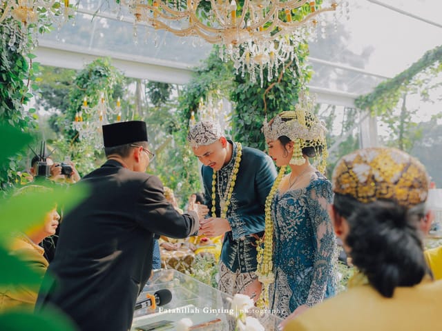 Javanese outdoor wedding at Felfest UI with glass structure and floral decor.
