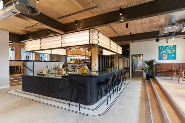 Industrial-chic meeting room with central bar for networking events and corporate conferences.