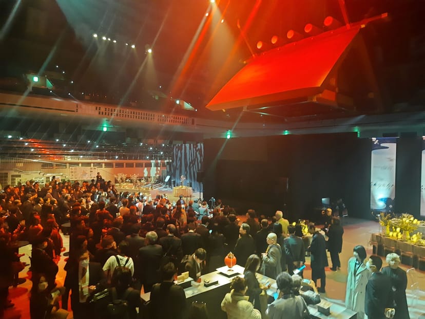 Networking reception at Kokugikan Arena with stage branding and crowd for corporate events.