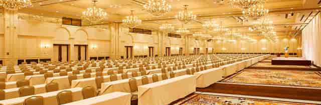Classroom-style ballroom with crystal chandeliers for large-scale corporate conferences or seminars.