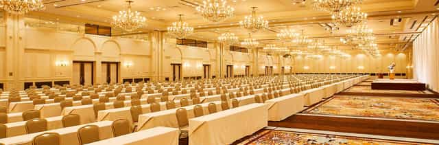 Classroom-style ballroom with crystal chandeliers for large-scale corporate conferences or seminars.