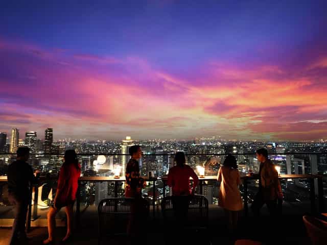 KITA Bar Park Hyatt Jakarta: Rooftop networking event with dramatic sunset skyline backdrop.