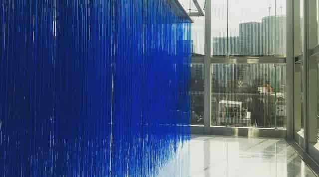 Blue fringe installation in Espace Louis Vuitton art gallery, ideal for corporate event venue.