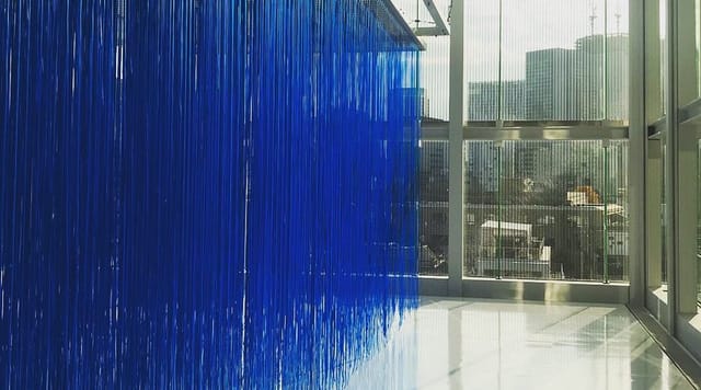 Blue fringe installation in Espace Louis Vuitton art gallery, ideal for corporate event venue.