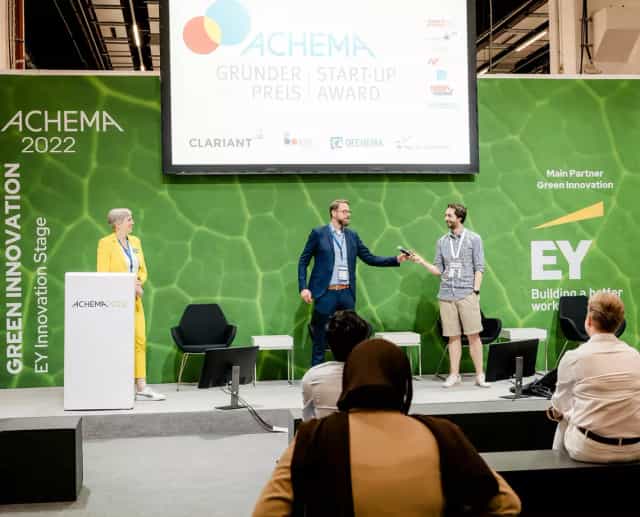 ACHEMA startup stage with green-screen backdrop for innovative event presentations.