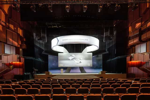 Modern corporate keynote stage setup in Grosser Saal with branded circular overhead rig.