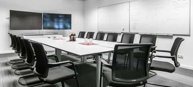 Boardroom setup in k1 BusinessClub with dual screens for corporate meetings and team workshops.