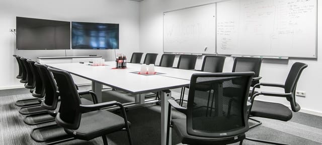 Boardroom setup in k1 BusinessClub with dual screens for corporate meetings and team workshops.