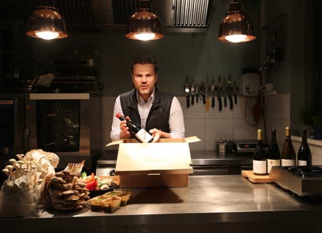 Professional chef in Frankfurt kitchen for virtual culinary and wine tasting events.