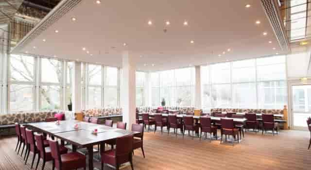Bright meeting room with floor-to-ceiling windows, ideal for corporate workshops and board meetings.