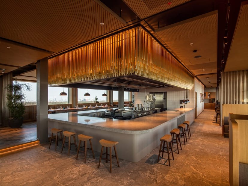 Modern rooftop restaurant with statement lighting for VIP reception and networking events.