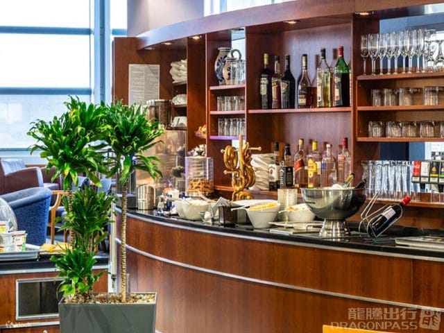 Modern airport lounge bar with organized glassware for executive event catering and travel.