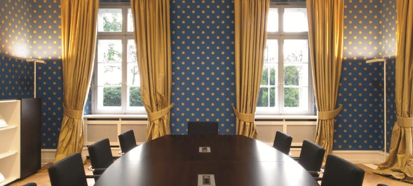 Blue Salon boardroom in Villa Metzler with polished table for executive meetings and conferences.