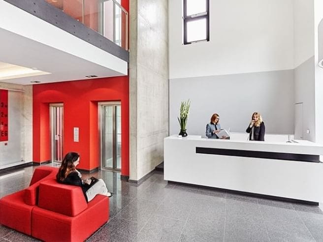Modern Agendis business center reception with red branding for professional event registration.