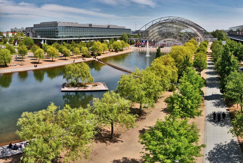 Leipziger Messe exhibition hall with landscaped grounds for corporate events and hybrid conferences.